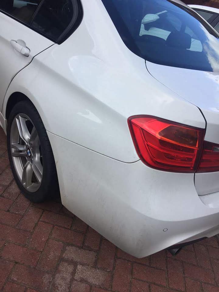 Rear of a white saloon car with the scuffed bumper repaired